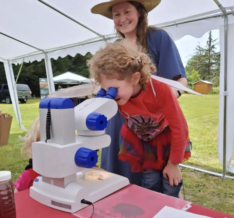 Kid looking into microscope